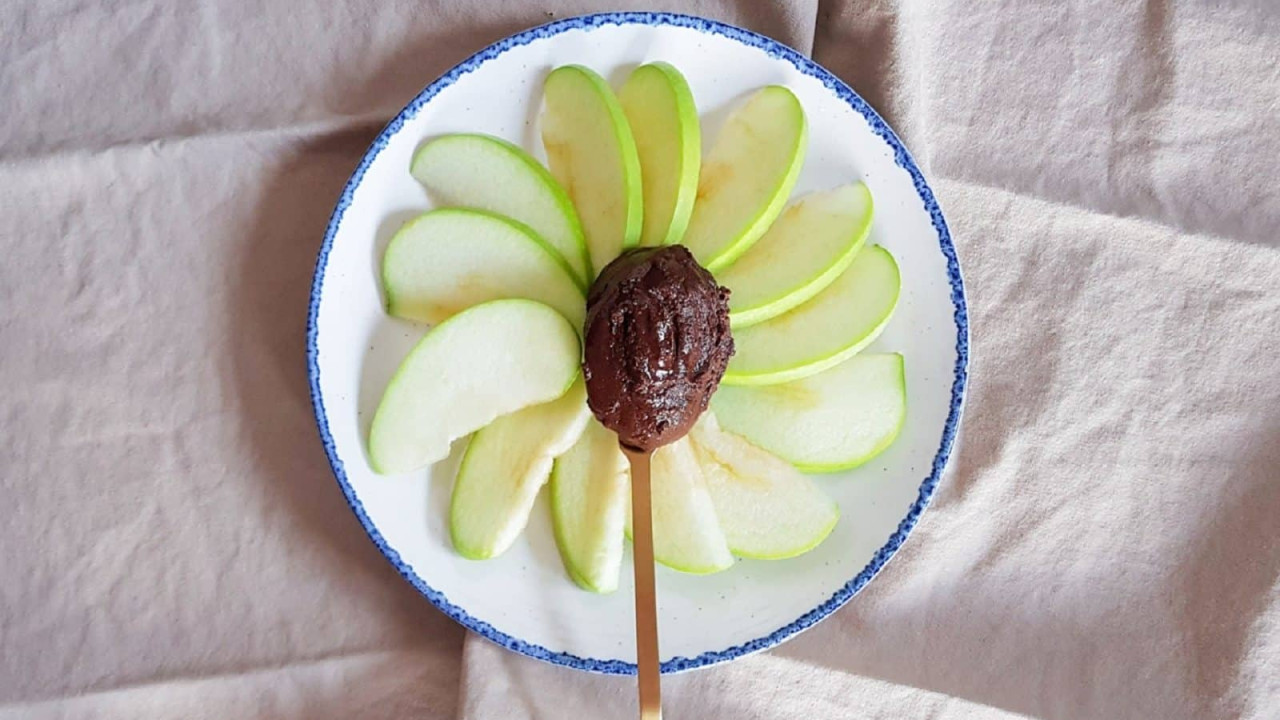 Nutella casera saludable servida sobre manzana cortada en rodajas