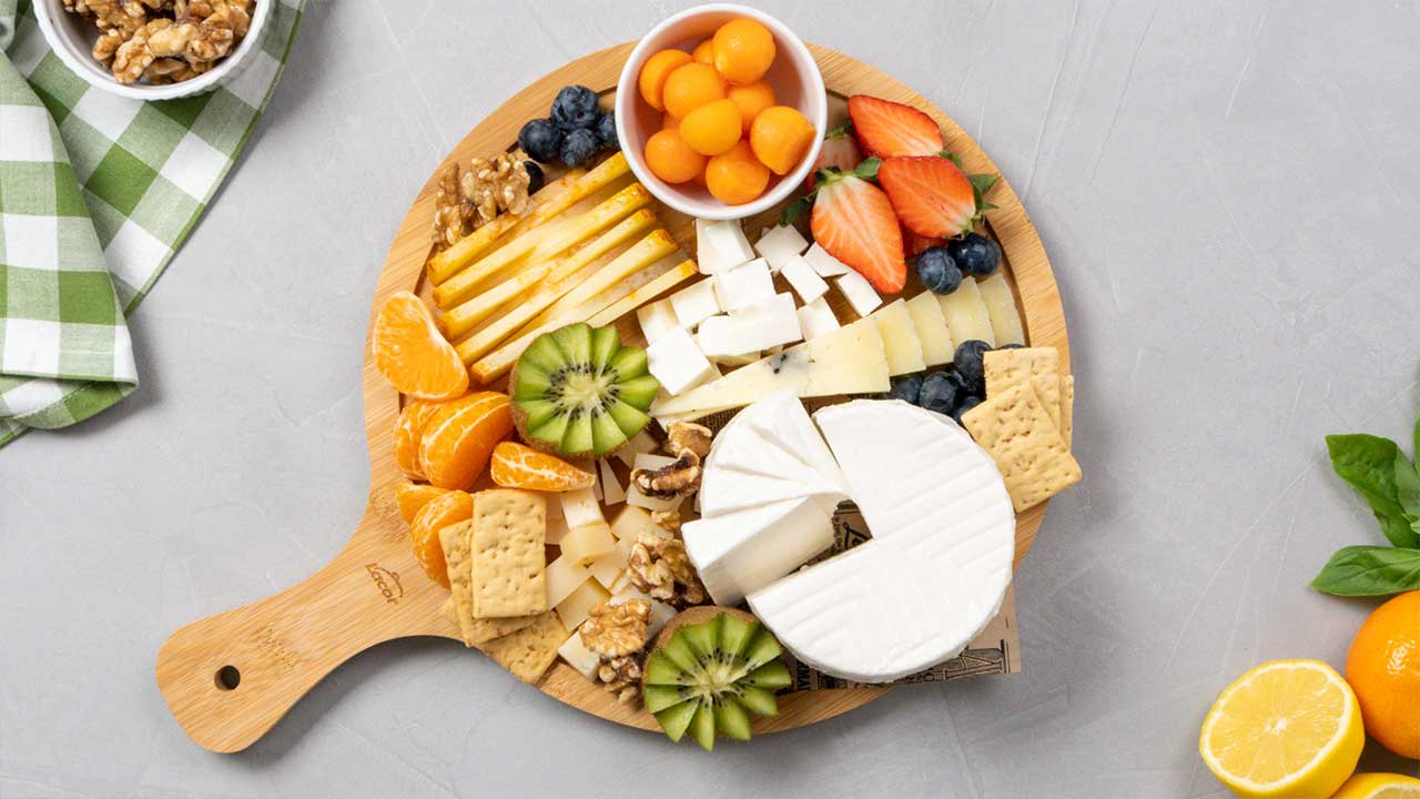 Tabla de queso y fruta vista en cenital con decoración